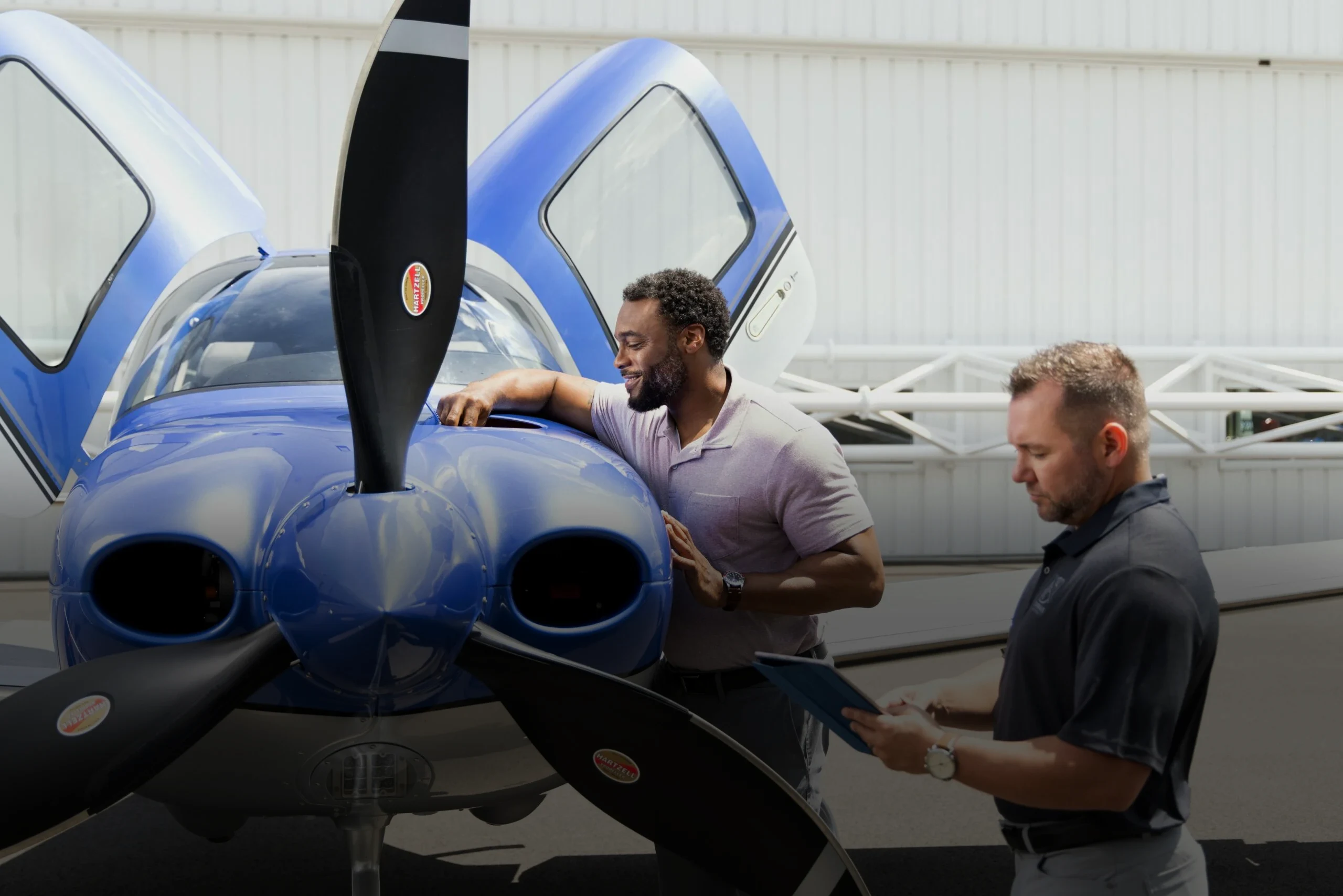 Instrutor e aluno checando aeronave Cirrus azul
